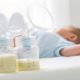 Breast milk pump and baby lying on the white bed. This article answers the question "will not pumping at night decrease my milk supply?"