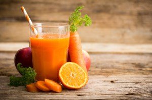 Carrot juice in a glass with a straw. 