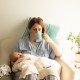 Woman drink tea or coffee during process of breastfeeding of newborn baby. Comfortable breastfeeding