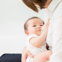 Baby being held by a woman. This post reviews how to induce lactation without pregnancy.